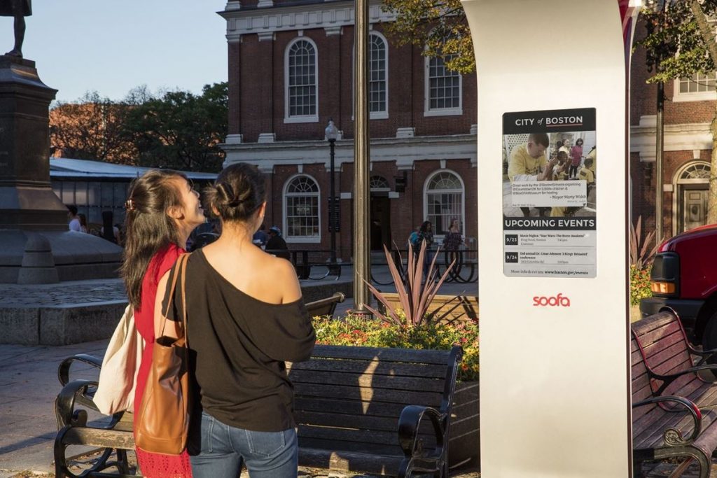 An image of people looking at the outdoor e-paper display.